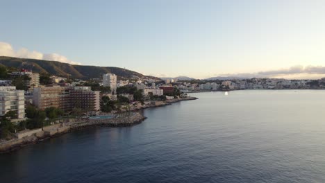 Golden-sunset-on-Mediterranean-island-Mallorca,-hotel-resorts-aerial-orbit