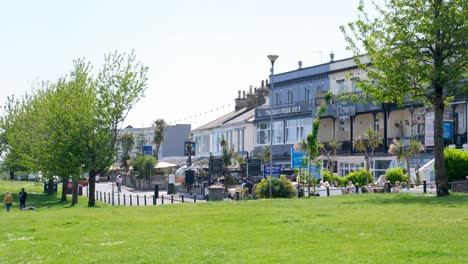 View-of-seaside-seafront-road-lined-with-hotels,-guesthouse-and-restaurants-in-popular-holiday-destination-in-Babbacombe,-Torquay,-Devon-in-England-UK