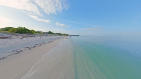 Cinematic-drone-flight-over-sandy-beach-and-clear-Caribbean-Sea