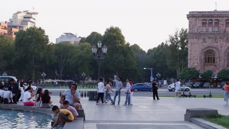 People-enjoy-warm-sunny-day-by-fountain-at-Yerevan-plaza-in-Armenia