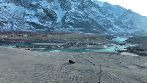 Toma-De-Gran-Angular-De-La-Captura-De-Un-Vehículo-Turístico-Que-Pasa-Por-El-Frío-Desierto-De-Sarfaranga---Valle-De-Skardu-En-Pakistán