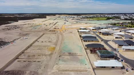 Reverse-aerial-view-over-new-housing-development-at-Amberton-Beach,-Perth-Australia