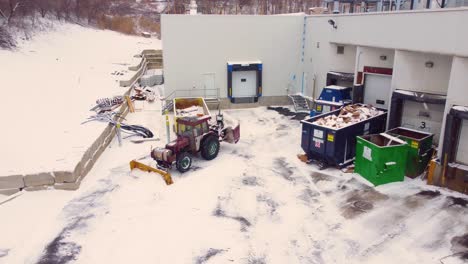 Traktor-Mit-Schneepflug-Räumen-Vor-Industriegebäude