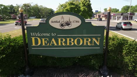 Welcome-to-Dearborn,-Michigan-sign-close-up-with-traffic