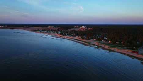 Aerial-rising-shot-approaching-the-coastline-of-Kalajoki-dunes,-sunset-in-Finland