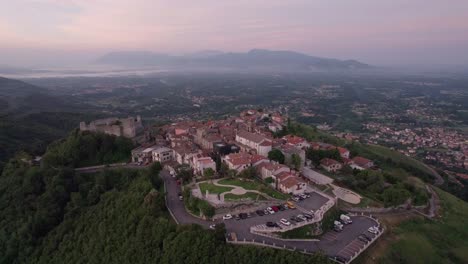 Antena-Hacia-El-Mágico-Castillo-De-San-Pietro-Romano-Al-Amanecer,-Italia