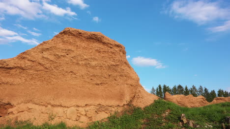 Lehmwand-Mit-Geschichteten-Schichten-Vor-Blauem-Himmel-In-Niedriger-Winkelansicht