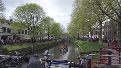 Bootsfahrt-Auf-Einem-Kanal-In-Utrecht-Während-Der-Feierlichkeiten-Zum-Königstag-Mit-Einer-Menschenmenge-Am-Ufer