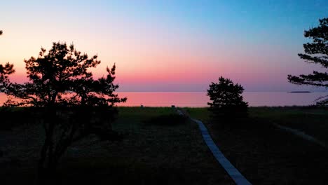 Wooden-Walking-Path-Leads-to-Colorful-Ocean-Sunrise-on-Beach