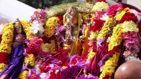 Ganesh-statue,-adorned-with-flowers,-is-carried-in-a-procession