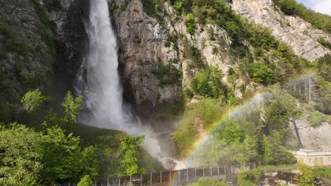 Impresionante-Vista-De-Las-Cataratas-Seerenbach-Cerca-De-Amden-Betlis,-Suiza,-Con-Un-Vibrante-Arco-Iris-Y-Una-Exuberante-Vegetación-Circundante.