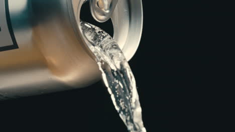 White-wine-or-clear-liquid-pouring-out-of-silver-can-in-super-slow-motion,-black-background-of-canned-drink-at-4k-800fps