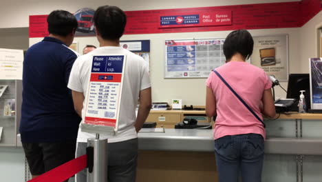 Motion-of-people-mailing-parcel-at-post-office-inside-shopper-drug-mart-store-with-4k-resolution