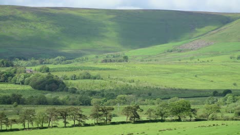 Las-Sombras-De-Las-Nubes-Se-Mueven-Rápidamente-A-Través-Del-Verde-Paisaje-Del-Valle-De-La-Campiña-Inglesa-Con-Una-Casa-De-Campo-Situada-En-La-Ladera-De-Una-Colina