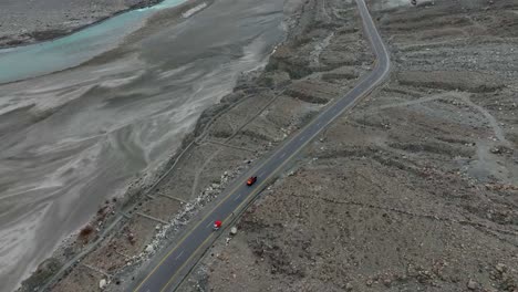 Toma-De-ángulo-Alto-De-Un-Vehículo-Circulando-Por-La-Carretera-Gilgit-En-Pakistán