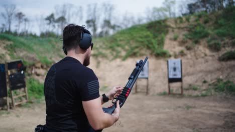 Shooter-load-new-shell-ammunition-into-shotgun-weapon,-Olesko-shooting-range