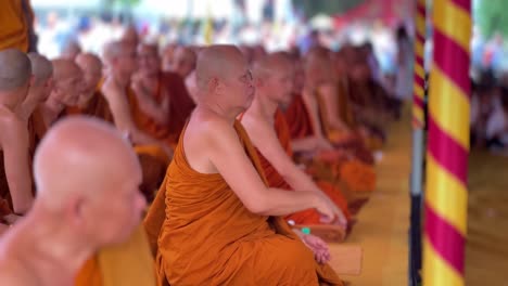 Viele-Mönche-Mit-Orangefarbener-Robe-Sitzen-Und-Beten-Im-Vesak,-Seitenansicht