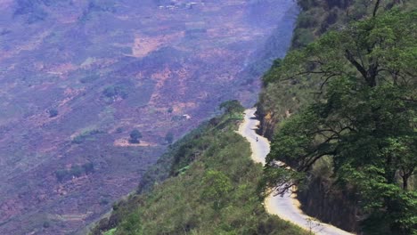 This-drone-footage-captures-a-morning-view-of-a-curvy-road-winding-through-the-mountains-of-Ha-Giang,-North-Vietnam