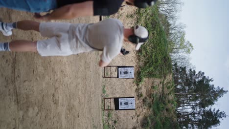 Shooting-instructor-corrects-beginner-shooter-weapon-holding-position,-Czechia