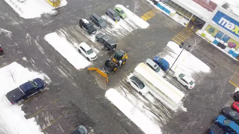 Snowplow-removes-melting-snow-from-parking-lot