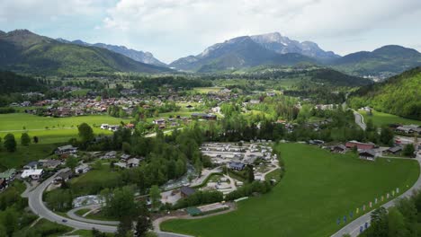 Aerial-view-of-picturesque-rural-scenery-near-the-village-of-Schönau-am-Königssee-in-the-Berchtesgaden-Alps-in-Bavaria-with-mountain-Untersberg-at-the-horizon