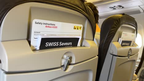 Swiss-Air-airplane-seats-inside-an-airbus-airplane-in-Switzerland,-safety-instructions,-traveling-in-Europe,-4K-shot