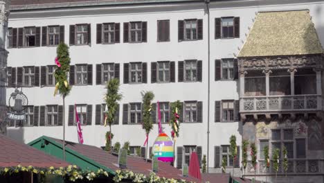 Roofs-of-the-stands-of-the-Easter-market-with-decorations-on-them-in-front-of-the-Golden-Roof-in-Innsbruck,-North-Tyrol,-Austria