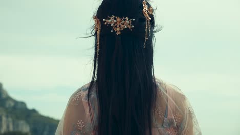 Chinese-Girl-Stares-at-Landscape-Above-Cliff