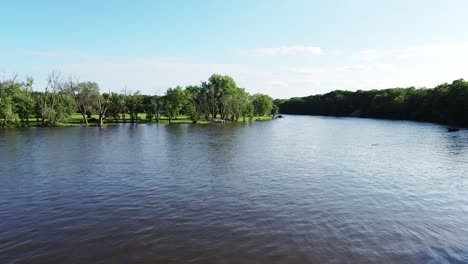 Drone-footage-flying-slowly-over-a-river-on-a-sunny-summer-day