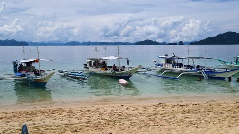 Barcos-Turísticos-Filipinos-Bangka-En-La-Costa-Arenosa,-Tours-A-Las-Islas-El-Nido,-Palawan,-Filipinas