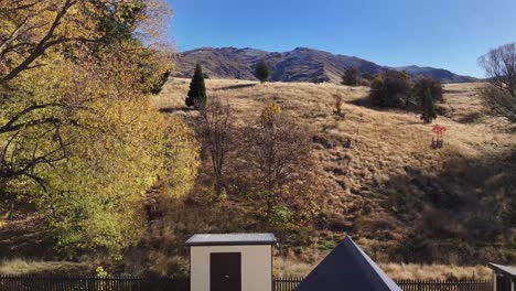 Drone-flyover-Cardrona-Hall,-old-wooden-building,-alpine-village-in-New-Zealand