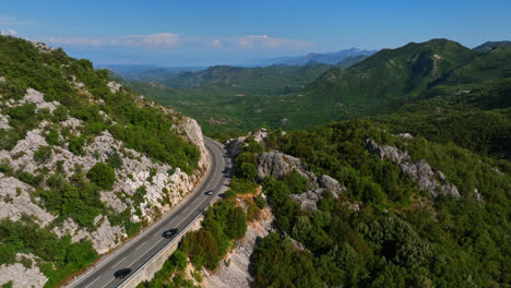 Vista-Aérea-Hacia-Atrás-Sobre-El-Tráfico-En-Las-Tierras-Altas-De-Budva,-Verano-En-Montenegro