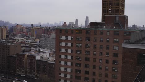 slow-moving-shot-of-residential-brick-building-contrasted-by-the-skyscrapers-line-the-horizon-on-a-gray-day