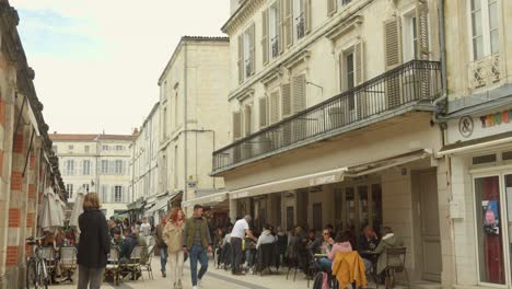 People-walking-at-historic-street-sign-in-La-Rochelle-city,-France