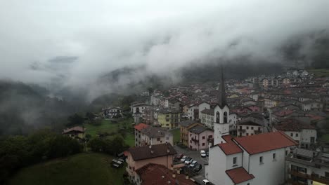 Drohnenschuss-An-Einer-Kirche-In-Einer-Nebligen-Italienischen-Bergstadt-Vorbei-4k