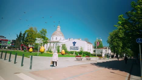 Pájaros-Volando-Sobre-La-Plaza-Central-De-Daugavpils-Con-Vistas-A-La-Iglesia-Católica-Romana-En-Un-Día-Soleado