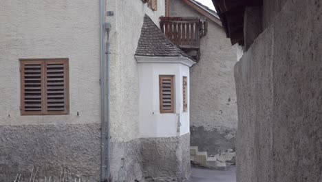 Zooming-put-on-a-narrow-alley-with-a-bay-window-in-the-town-of-Laatsch---Laudes,-South-Tyrol,-Italy