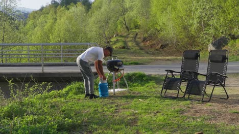 Mann-Stellt-Grillausrüstung-Für-Das-Abendessen-Auf,-Mit-Blauer-Gasflasche-Für-Den-Grill