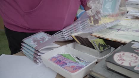 Person-arranges-several-books-on-a-table-to-sell-at-a-university-book-fair