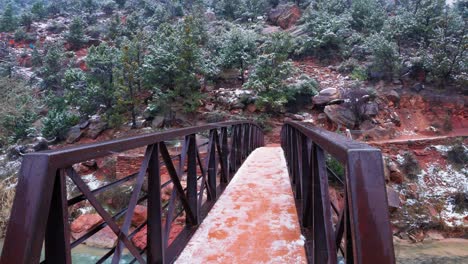 A-Narrow-bridge-with-snow-on-it-while-flakes-soar-past-the-camera-in-Zion-National-Park