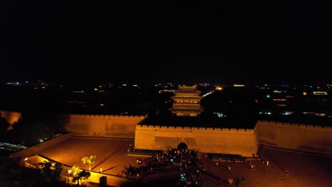 Toma-Aérea-Muestra-Turismo-Masivo-En-La-Puerta-Sur-De-Pingyao-Mientras-Otro-Dron-Vuela-Alrededor