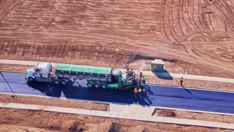 Vista-Aérea-Cercana-De-Un-Camión-Y-Una-Máquina-Pavimentadora-Trabajando-En-Una-Nueva-Etapa-En-Silverwoods-Estate