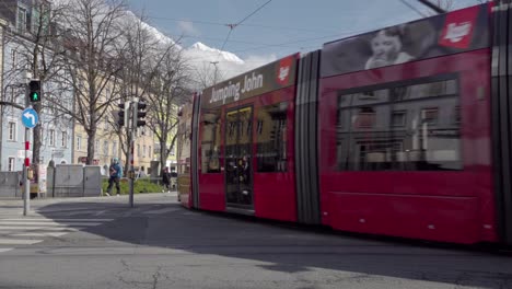 Eine-Straßenbahn-Fährt-In-Eine-Haltestelle-Ein,-Fahrgäste-Steigen-Ein-Und-Aus-Und-Die-Straßenbahn-Verlässt-Die-Haltestelle