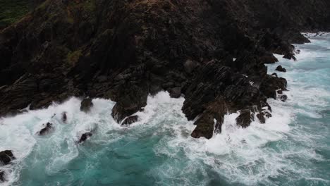 Aerial-View-of-South-Pacific-Ocean-Waves-Crashing-on-Rocks-of-Byron-Bay-Cape,-Australia