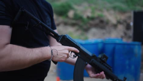 Caucasian-male-attach-magazine-with-combat-bullets-on-weapon,-Olesko,-Czechia