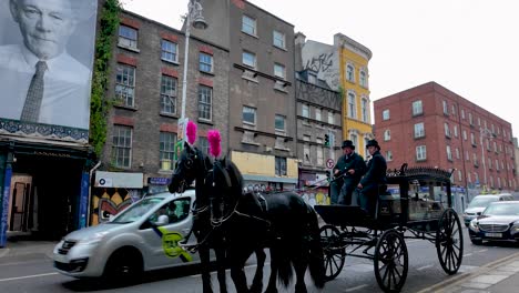 Eine-4K-Straßenaufnahme-Eines-Von-Pferden-Gezogenen-Leichenwagens-Auf-Einer-Straße-In-Dublin,-Irland