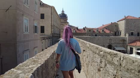 Person-strolls-amidst-the-ancient-City-Walls-of-Dubrovnik,-Croatia,-capturing-the-essence-of-tourism,-travel,-and-exploration,-adventure-and-discovery-in-one-of-Europe's-enchanting-destinations