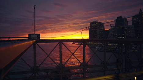 Brooklyn-Bridge-Bei-Sonnenuntergang-Und-Lower-Manhattan-Mit-Vorbeifahrenden-Autos