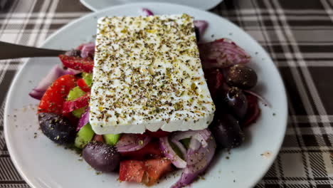 Greek-Salad-Side-Dish-With-Feta-Cheese-Slice-On-Top,-Sprinkled-With-Dry-Oregano