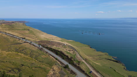 Coches-Circulando-Por-Una-Carretera-Costera-En-La-Isla-De-Skye-Con-Una-Gran-Vista-Del-Océano.